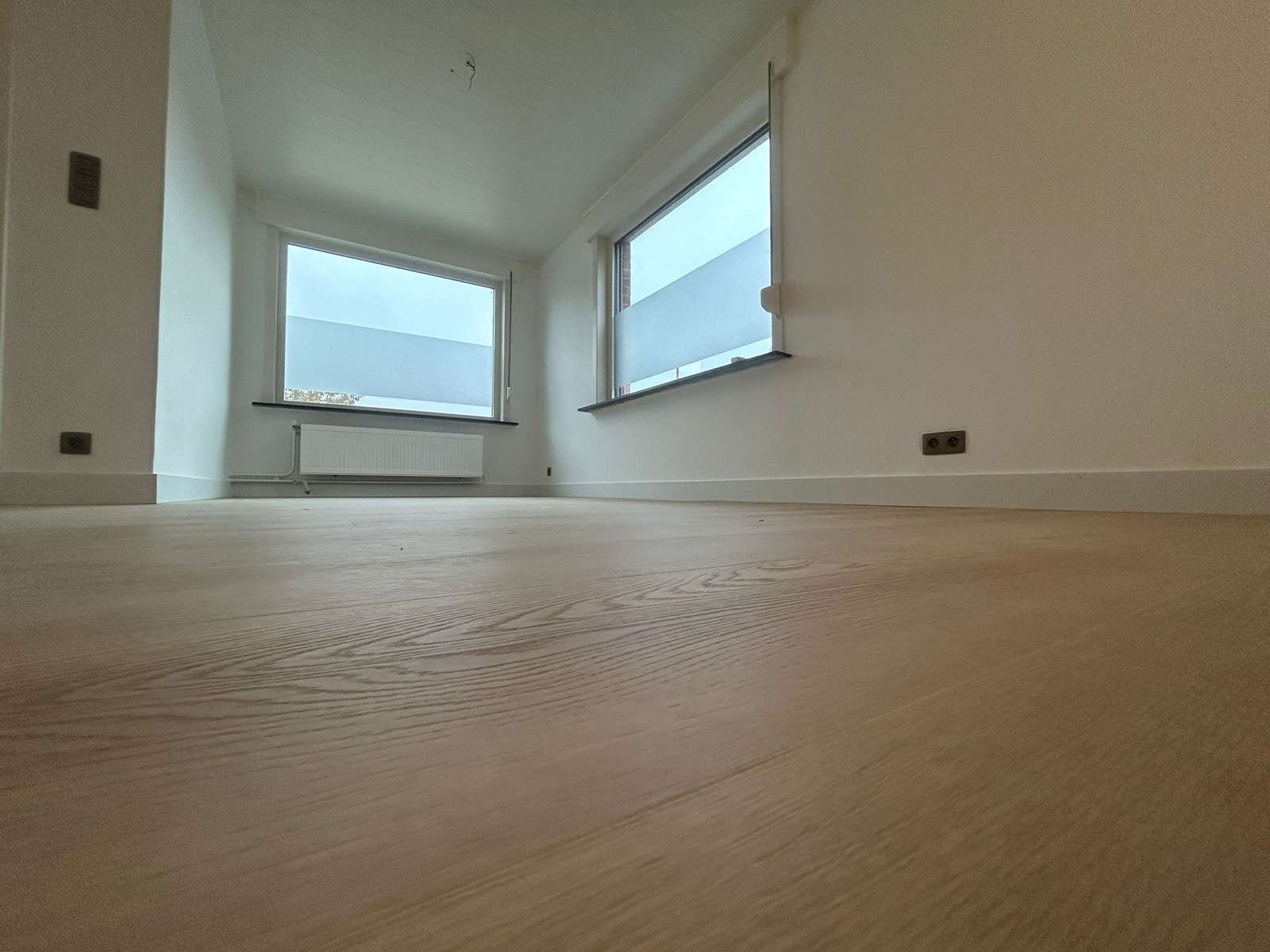 Afwerking van muur en laminaatvloer door Verbrugghe